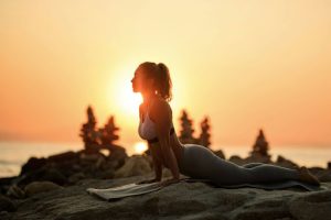 Woman practicing yoga at sunrise as part of a holistic wellness lifestyle aligned with Sisel International’s focus on balance, movement, and long-term health.