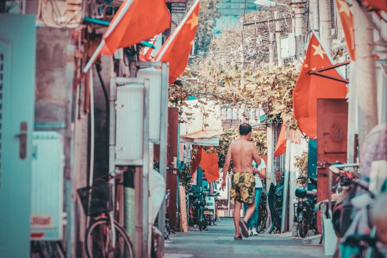 A vibrant street in Beijing featuring flags and a person walking during daylight