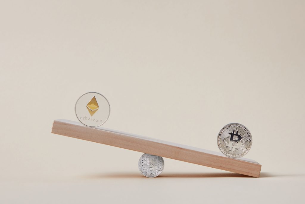 Minimalist image of Ethereum and Bitcoin coins balancing on a plank, symbolizing crypto market dynamics