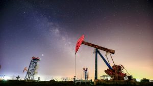 Oil pumpjacks under a starry night sky