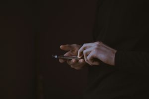 Hands using a smartphone in a dark setting