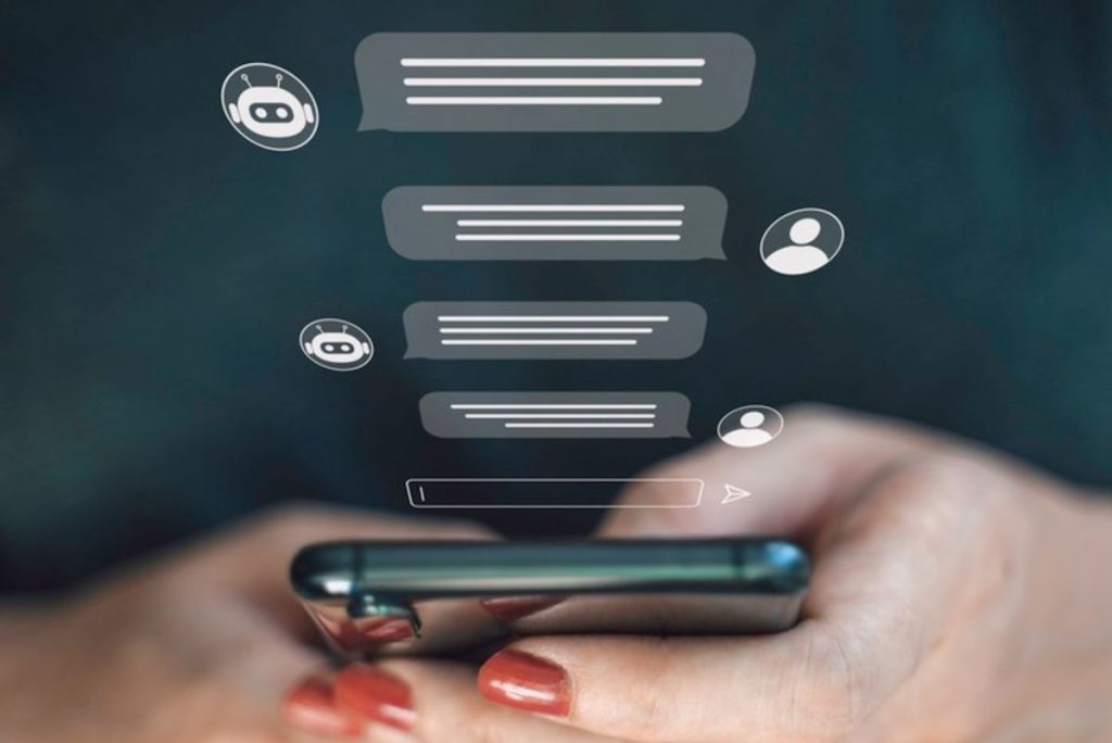 Hands hold a smartphone beneath illustrated chatbot conversation bubbles